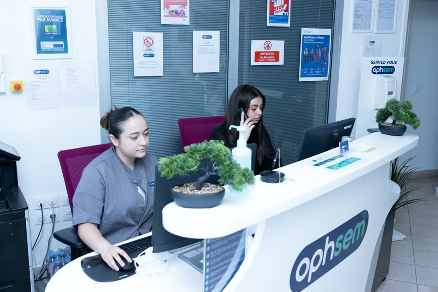 Le comptoir d'accueil du centre de santé Ophsem, où deux membres de l'équipe reçoivent les patients