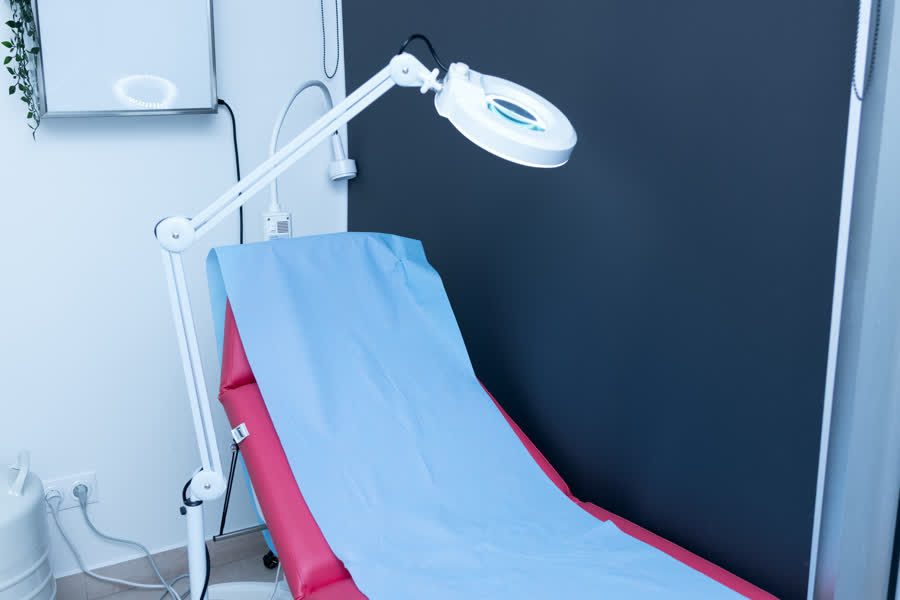 Table d'examen et lampe loupe dans la salle de dermatologie